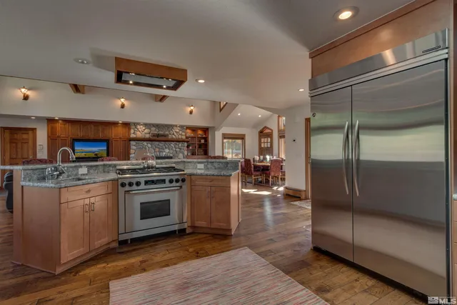 a kitchen with stainless steel appliances granite countertop a refrigerator a stove and a sink