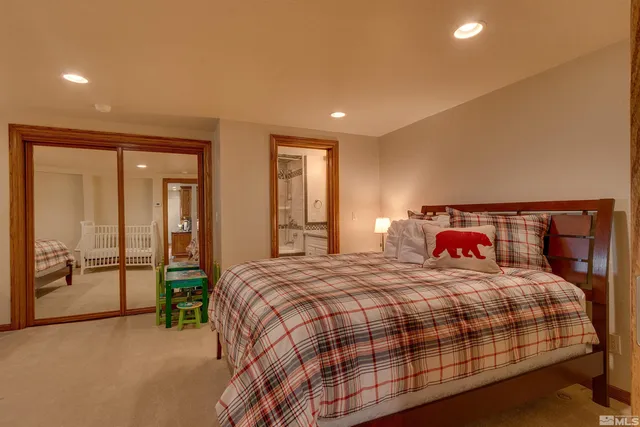 a bedroom with a large bed and a chandelier