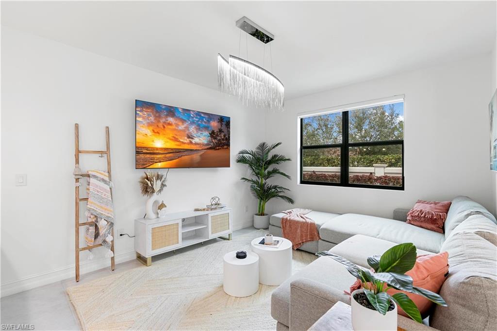 7578 Rockefeller Drive Naples, FL 34119 - Photo 11 of 39 a living room with furniture a window and a flat screen tv