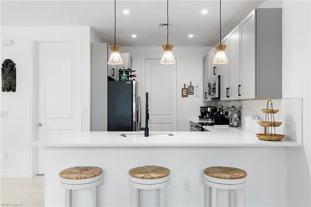 a bathroom with a sink a large mirror and a refrigerator
