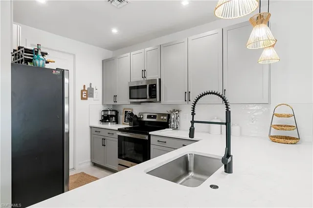 a kitchen with granite countertop a sink stainless steel appliances and cabinets