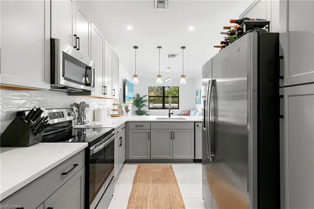 a kitchen with stainless steel appliances a refrigerator sink and microwave