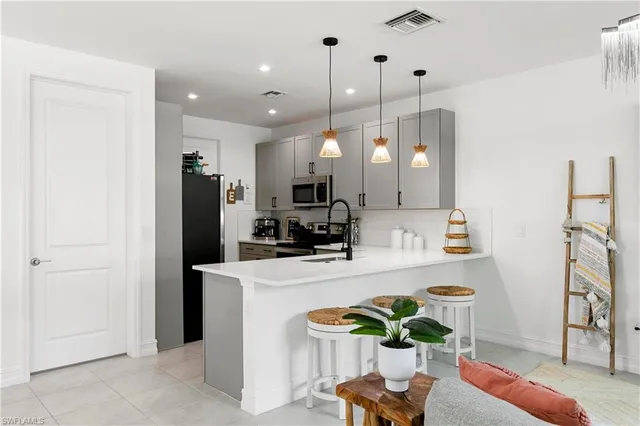 a kitchen with stainless steel appliances granite countertop a refrigerator a sink a stove and a wooden floors