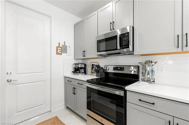 a kitchen with stainless steel appliances white cabinets and a stove a oven with white countertops