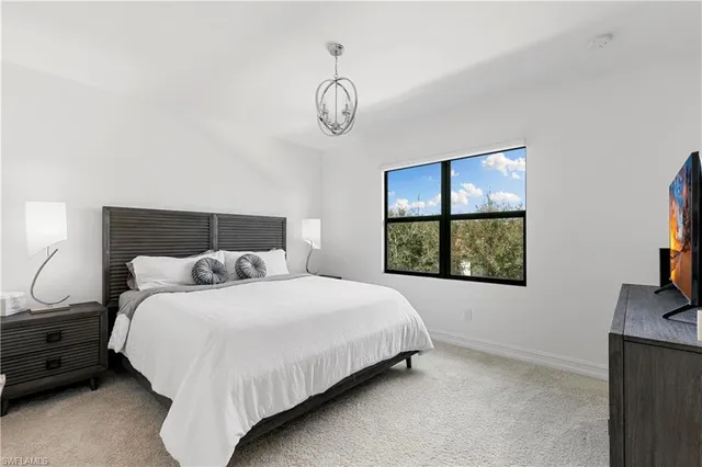 a bedroom with a bed and a flat tv screen on the dresser