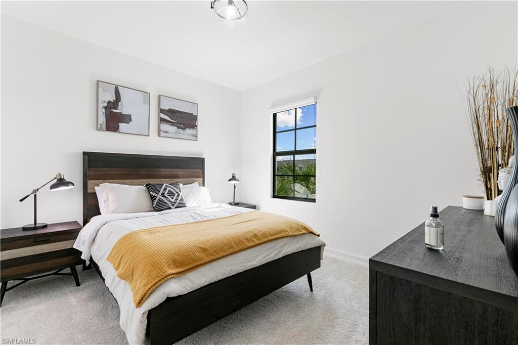 7578 Rockefeller Drive Naples, FL 34119 - Photo 27 of 39 a bedroom with a bed and a table in it