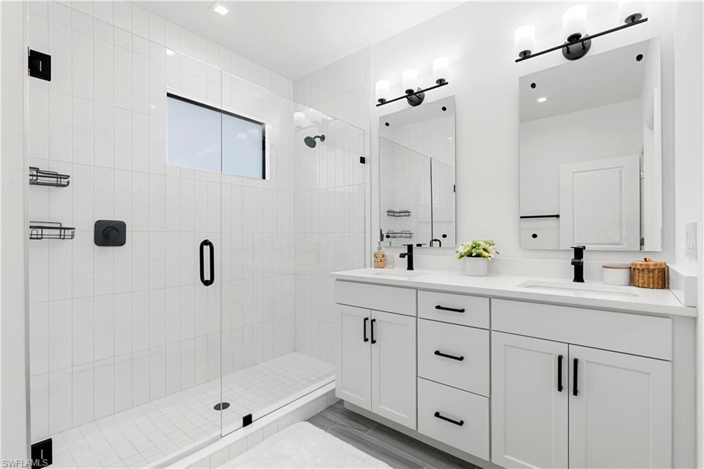 7578 Rockefeller Drive Naples, FL 34119 - Photo 28 of 39 a bathroom with a shower sink and mirror