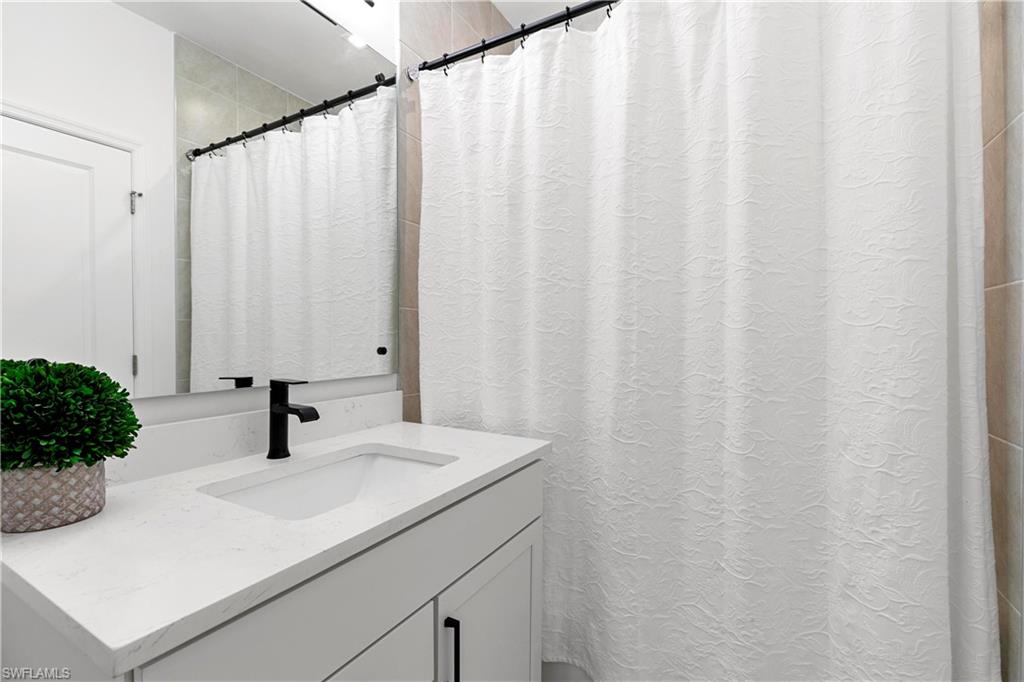 7578 Rockefeller Drive Naples, FL 34119 - Photo 30 of 39 a bathroom with a sink and a mirror