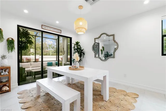 a dining room with wooden floor a chandelier a glass table and chairs