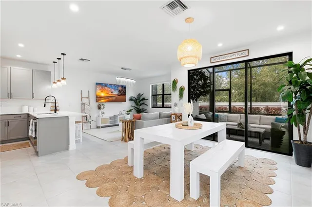 a living room with fireplace furniture and a view of kitchen