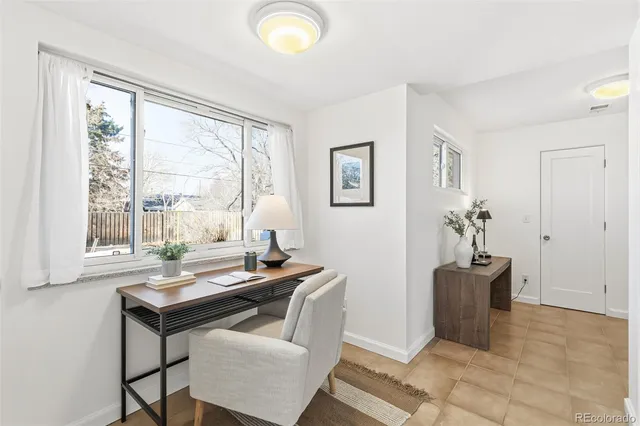 a view of a workspace with furniture and a window