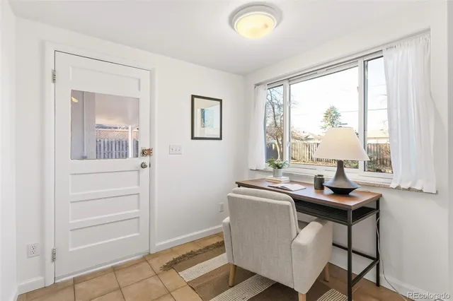a view of a workspace with furniture and a window