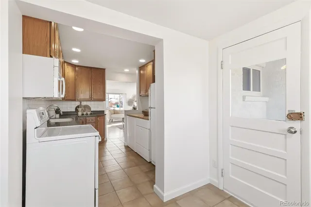 a kitchen with a sink dishwasher a refrigerator and cabinets