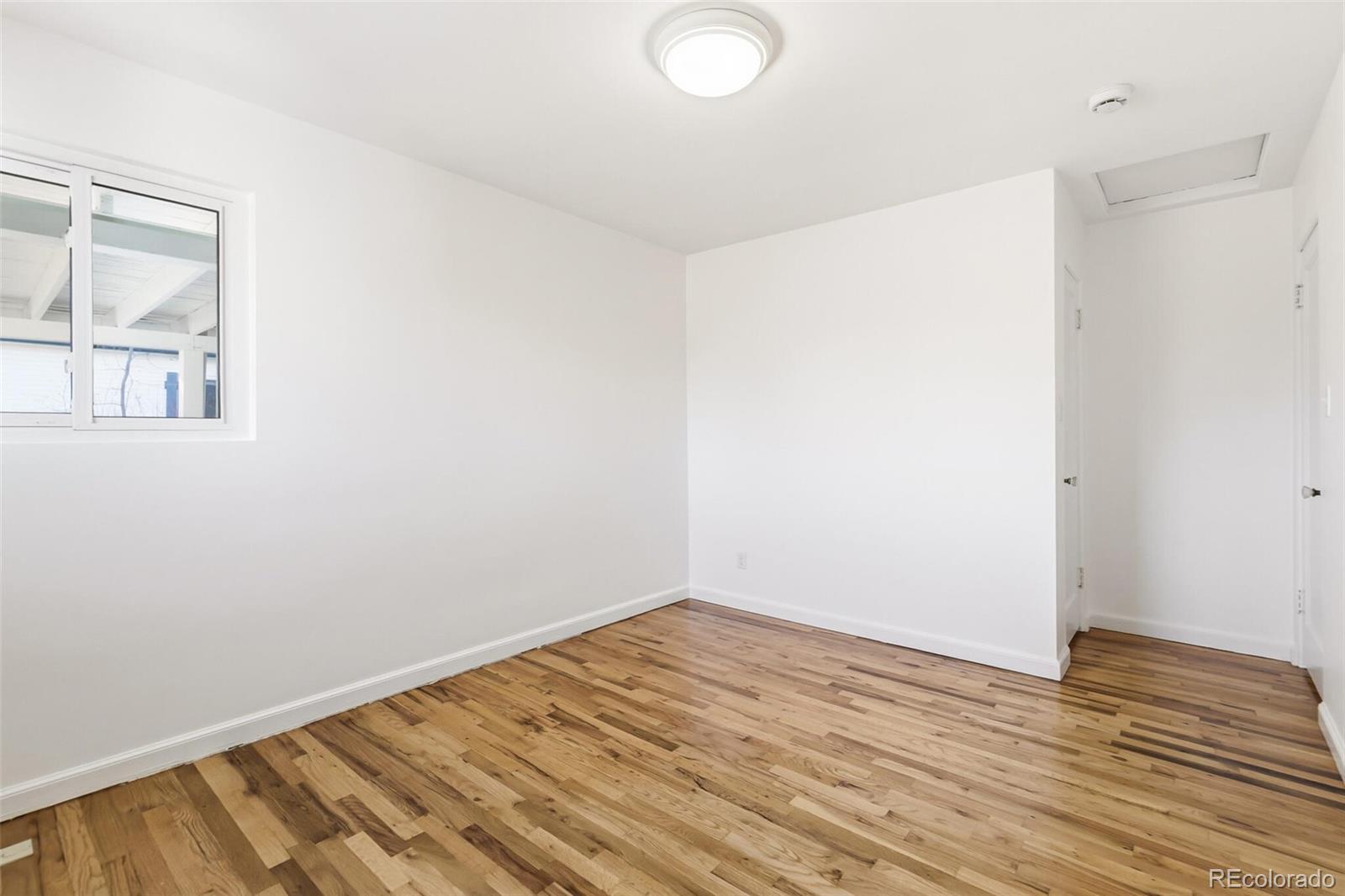 4535 Zephyr Street Wheat Ridge, CO 80033 - Photo 27 of 35 an empty room with wooden floor and windows