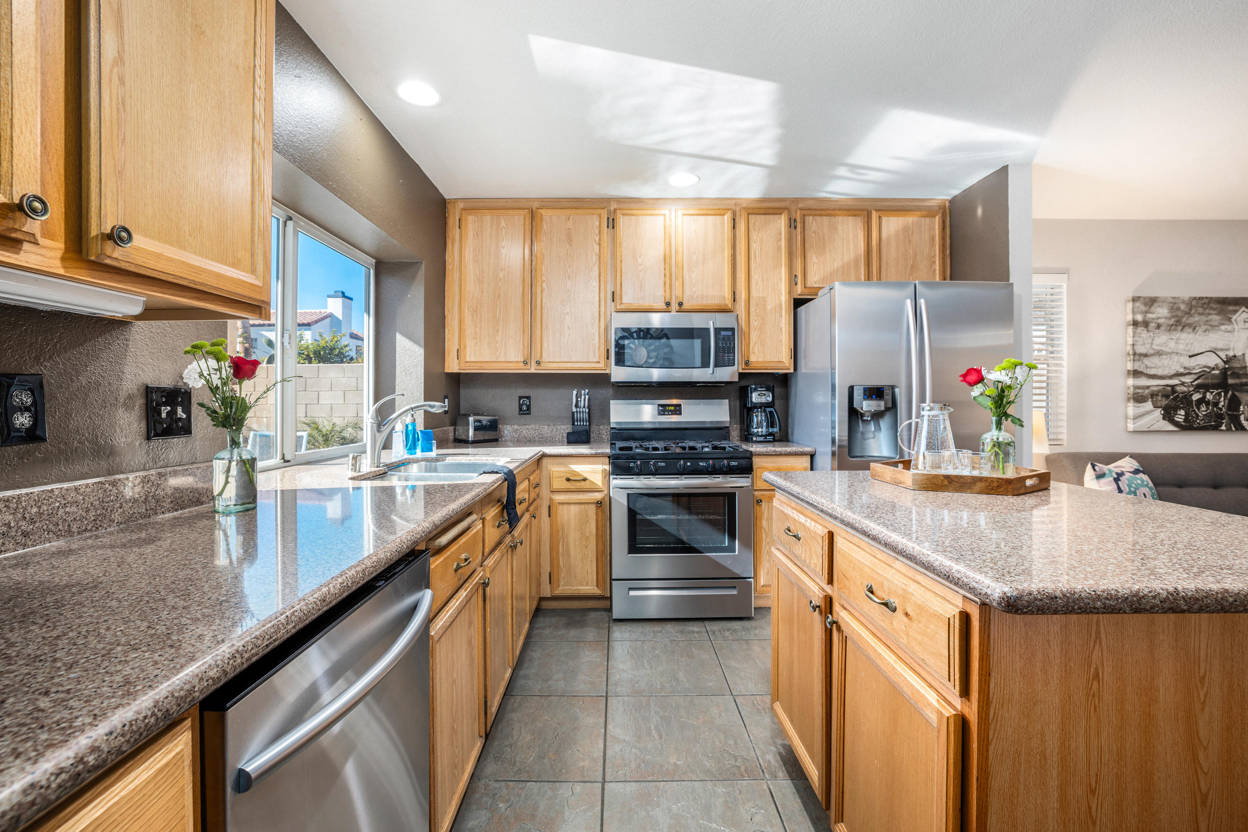 80721 Sycamore Lane Indio, CA 92201 - Photo 9 of 35 a kitchen with kitchen island granite countertop a sink counter top space cabinets and stainless steel appliances