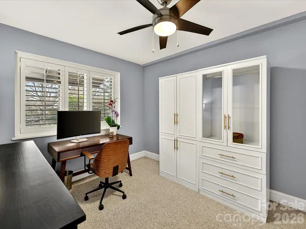 a view of a workspace with furniture and a window