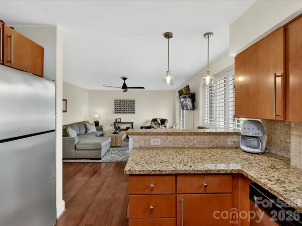 a view of a kitchen with kitchen island a counter top space a sink stainless steel appliances and cabinets