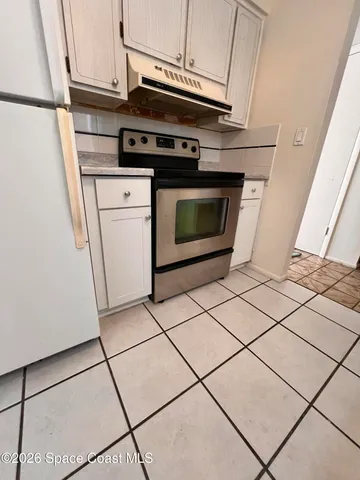 a kitchen with granite countertop a stove and a microwave