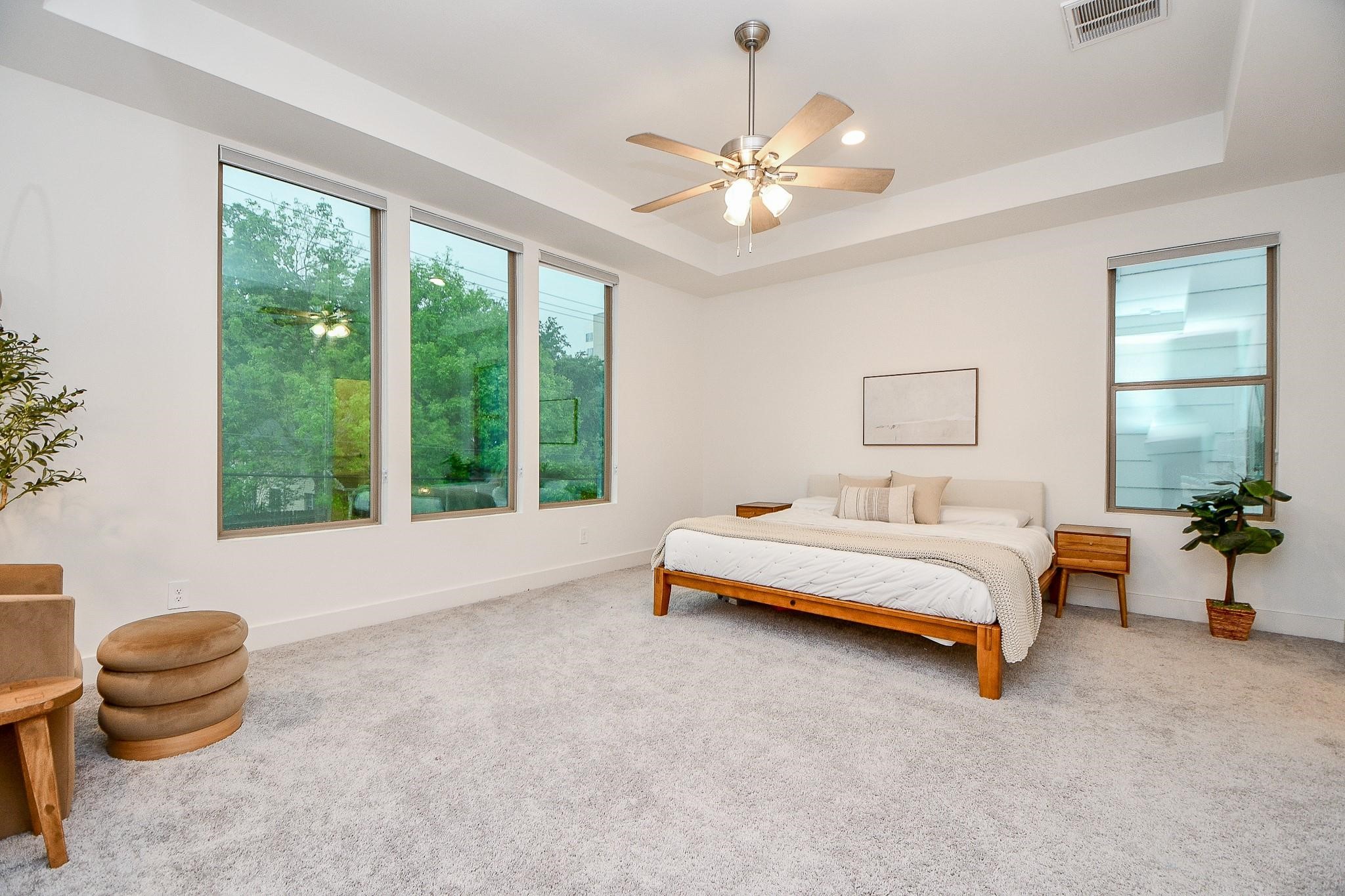 4403 Greeley Street Houston, TX 77006 - Photo 16 of 28 a spacious bedroom with a bed and a chandelier