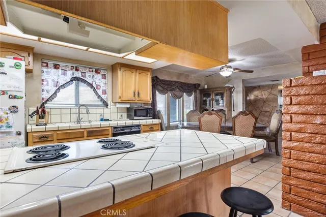 a kitchen with stainless steel appliances granite countertop a sink a stove and a wooden cabinets