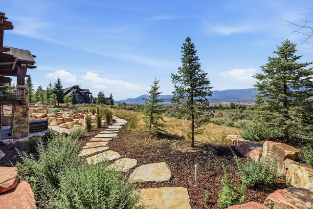 7885 North Rabbitbrush Court, Unit 13 Park City, UT 84098 - Photo 76 of 88 Stone paver pathway winding through natural landscaping with mature evergreens and scattered boulders