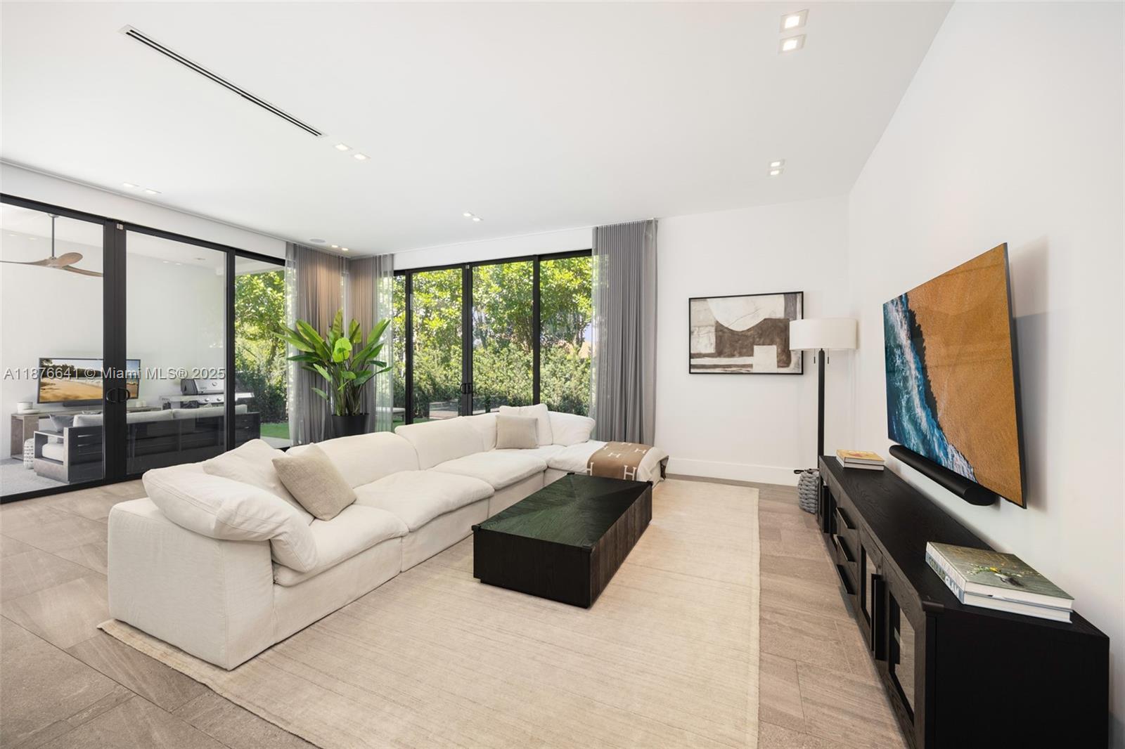 2321 Trapp Avenue Coconut Grove, FL 33133 - Photo 10 of 38 a living room with furniture flat screen tv and a large window