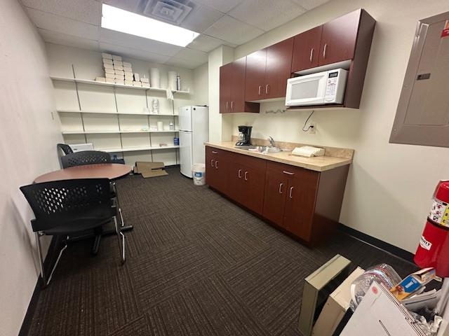 31 Central Boulevard Babbitt, MN 55706 - Photo 7 of 14 Kitchen with a paneled ceiling, electric panel, light countertops, white appliances, and an office area