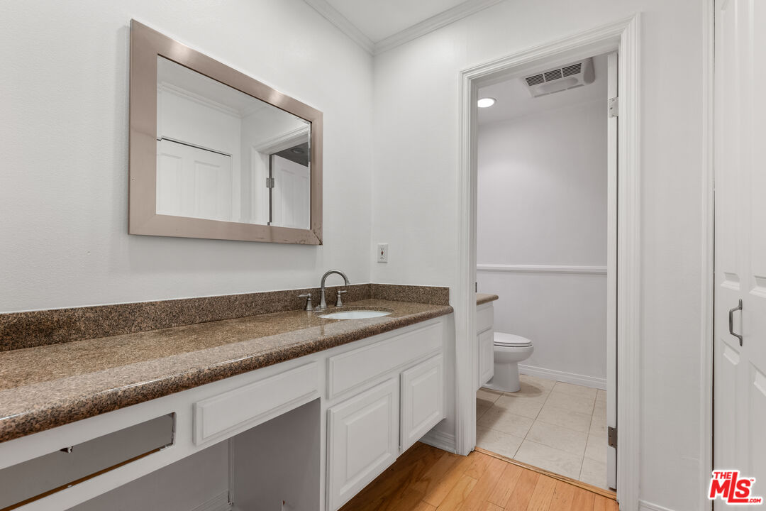 7202 Raintree Circle Culver City, CA 90230 - Photo 7 of 17 a bathroom with a granite countertop toilet sink and mirror