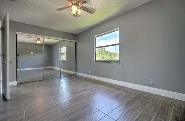 an empty room with fan and windows