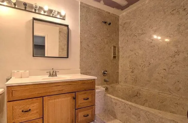 a bathroom with a sink a mirror and a bathtub
