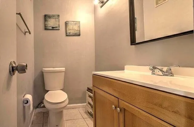 a bathroom with a granite countertop sink toilet and a mirror