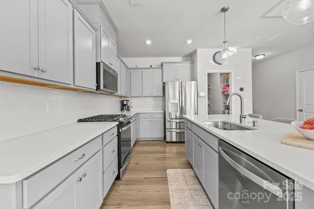 a kitchen with stainless steel appliances kitchen island granite countertop a sink and cabinets