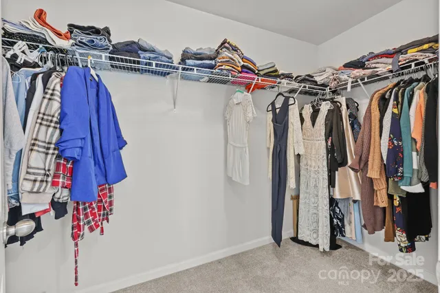 a view of a hallway with wooden floor and closet area