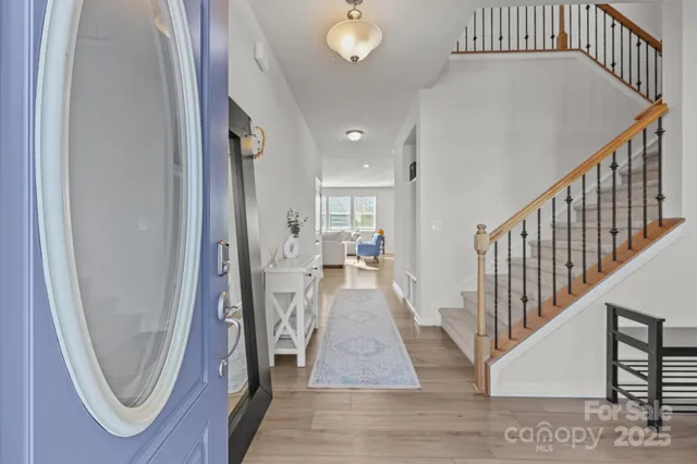 a view of a hallway with wooden floor and staircase
