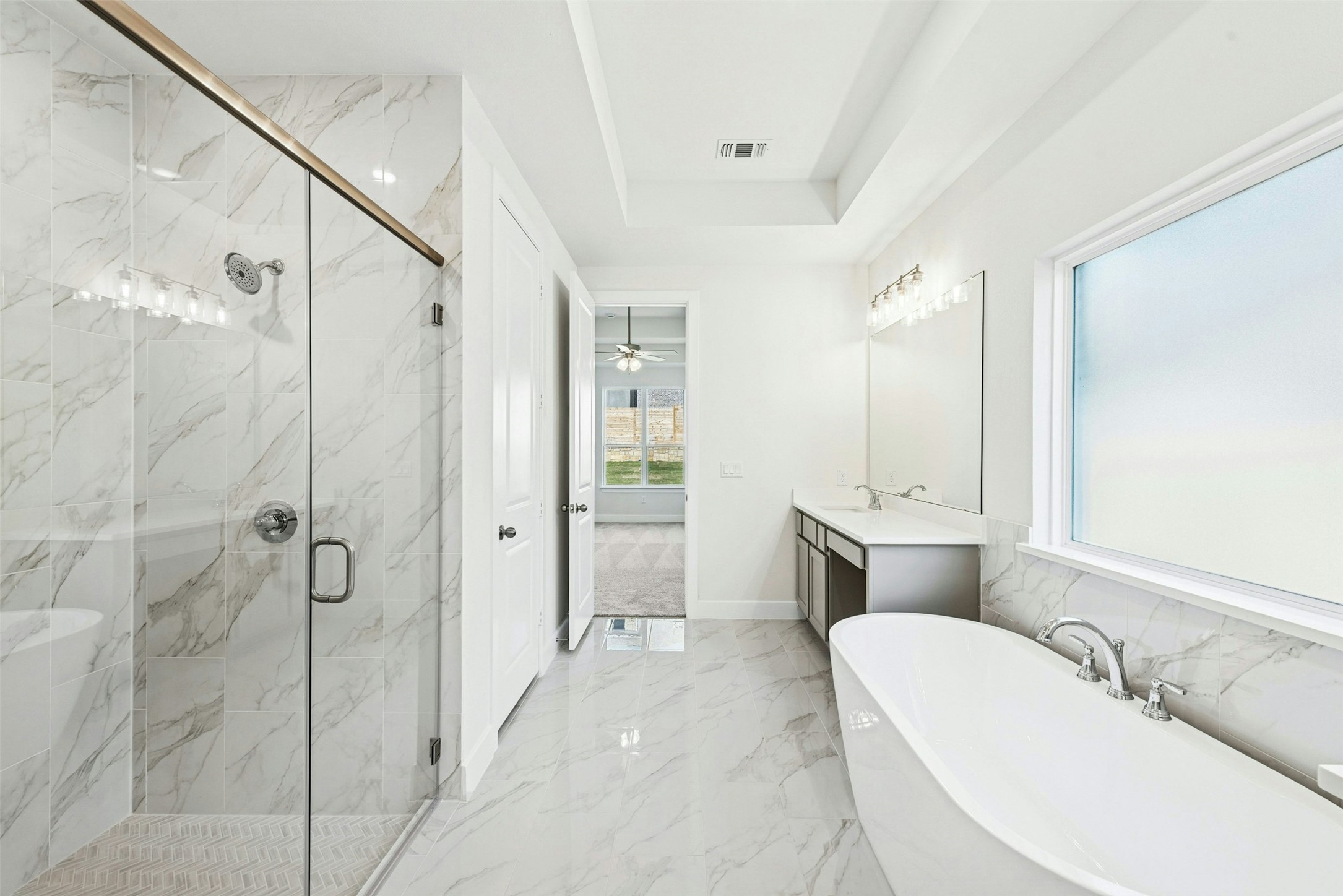 1520 Rodeo Ridge Drive Georgetown, TX 78628 - Photo 10 of 29 Full bath with a freestanding bath, light marble finish floors, vanity, a marble finish shower, and a tray ceiling