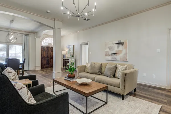 a view of a kitchen island with granite countertop stainless steel appliances a sink and a chandelier