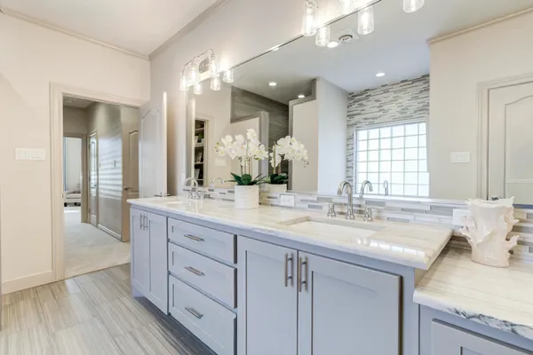a bathroom with a granite countertop bathtub shower sink vanity and toilet