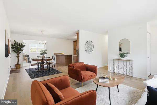 a dining room with stainless steel appliances kitchen island granite countertop a dining table chairs and a refrigerator