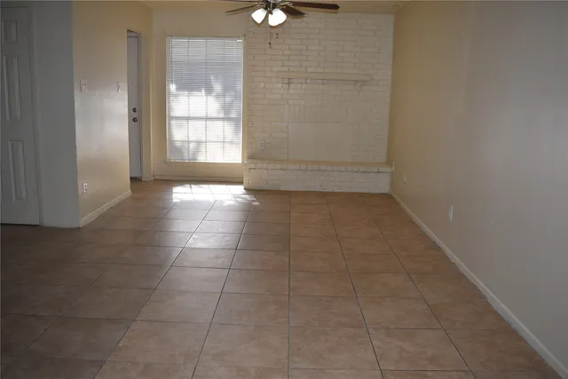 a view of an empty room and window of bathroom