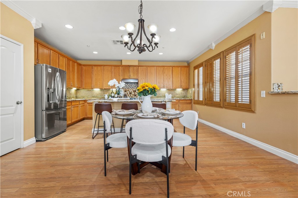 11450 Church Street, Unit 23 Rancho Cucamonga, CA 91730 - Photo 12 of 44 a dining room with furniture a chandelier and wooden floor