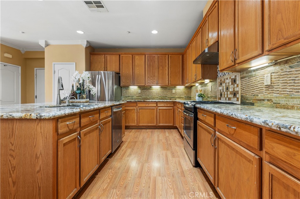 11450 Church Street, Unit 23 Rancho Cucamonga, CA 91730 - Photo 15 of 44 a large kitchen with granite countertop a sink counter space and cabinets