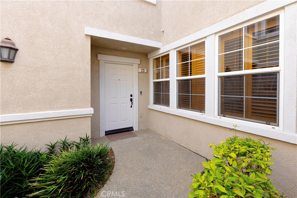 11450 Church Street, Unit 23 Rancho Cucamonga, CA 91730 - Photo 34 of 44 a front view of a house with a large window and a potted plant
