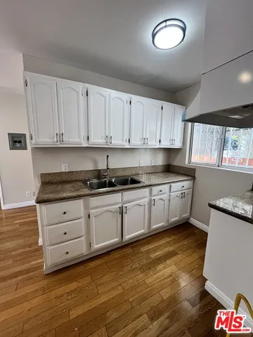 a kitchen with granite countertop white cabinets white appliances a sink and a stove