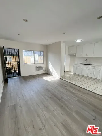 a view of empty room with wooden floor and window
