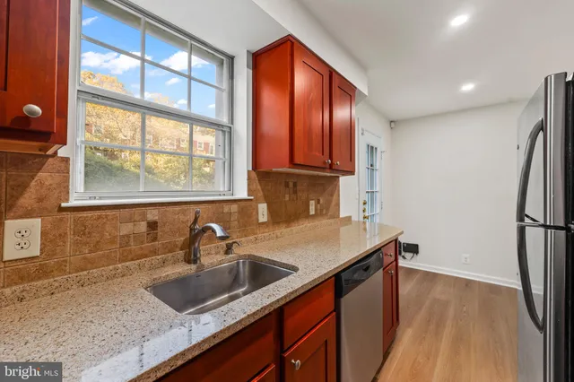 a kitchen that has a sink a refrigerator and window