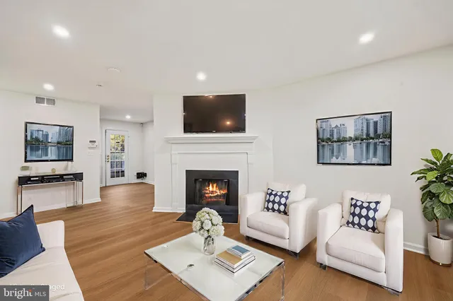 a living room with furniture a flat screen tv and a fireplace