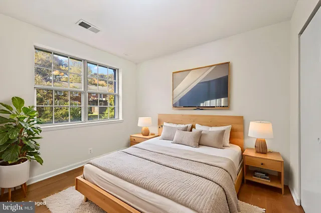 a bedroom with a bed and a potted plant