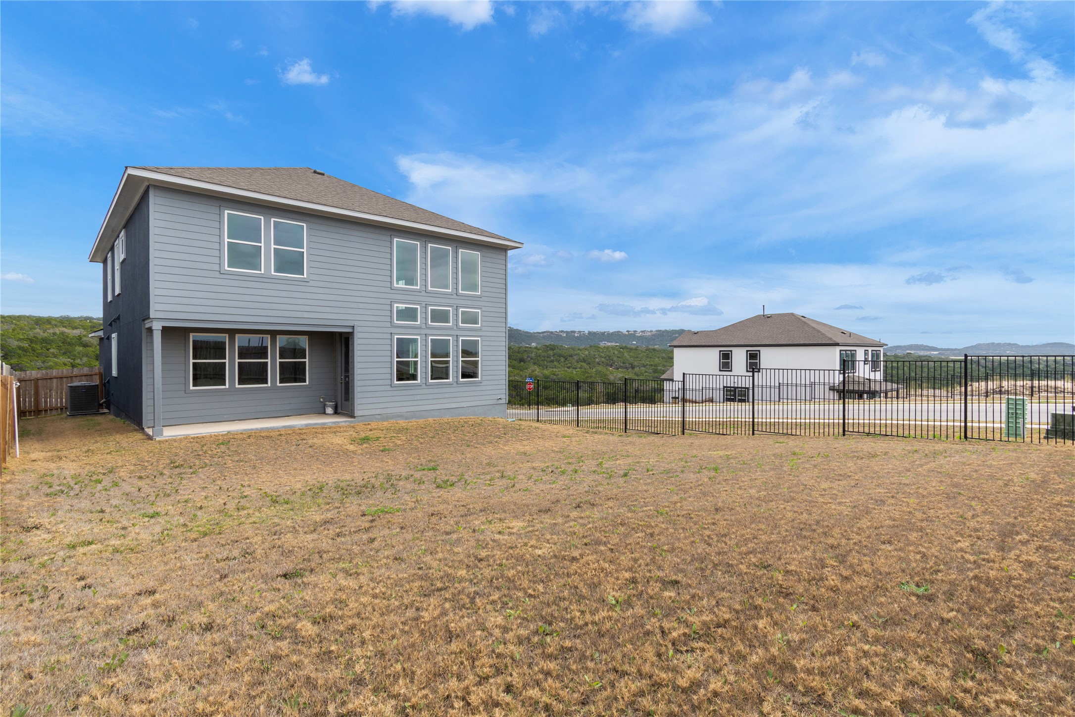 8500 Red Bottle Brush Road Lago Vista, TX 78645 - Photo 30 of 33 A contemporary residence with ample windows offers hillside views, blending modern design with a scenic backdrop.