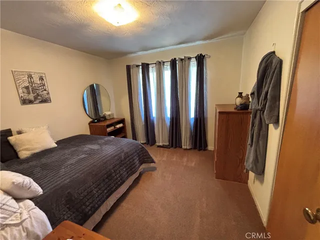 a bedroom with a large bed closet and a flat tv screen