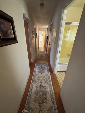 a view of a hallway with wooden floor and stairs